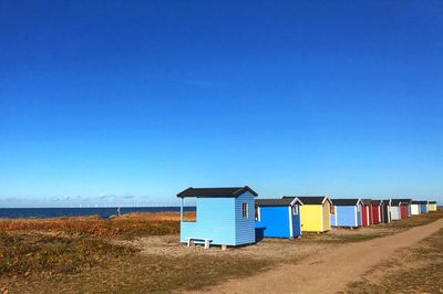 Beach hut against clear blue sky