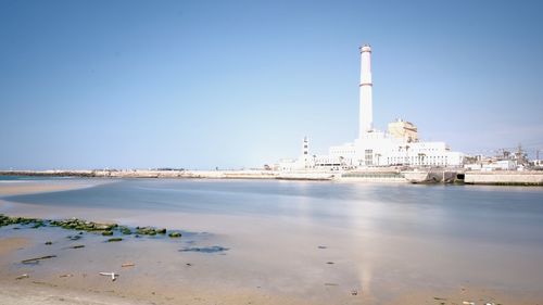 Lighthouse by sea against sky