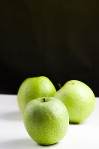 Close-up of apples on table against black background
