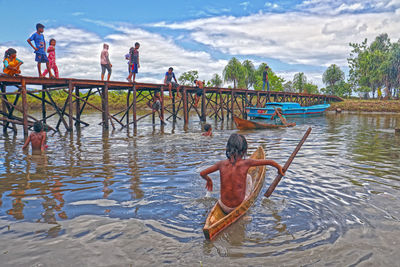 People on lake against sky