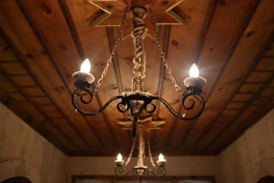 Low angle view of illuminated pendant light hanging from ceiling