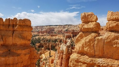 Panoramic view of rocks on landscape against cloudy sky