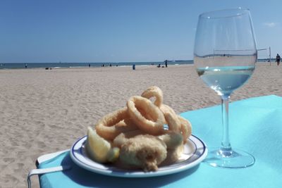 Close-up of ice cream on table at beach against sky