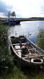 Boats moored on lake against sky