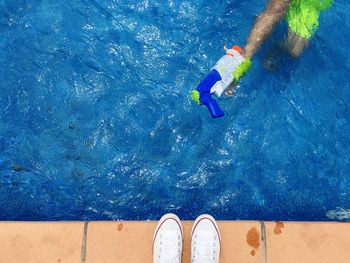 High angle view of child with squirt gun in swimming pool