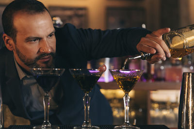 Male bartender preparing cocktail at bar counter