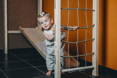 Active games for baby indoors activities. toddler girl play on home wooden indoor playsets. 