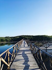 Footbridge against clear blue sky