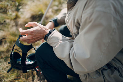 Midsection of man holding umbrella while sitting outdoors