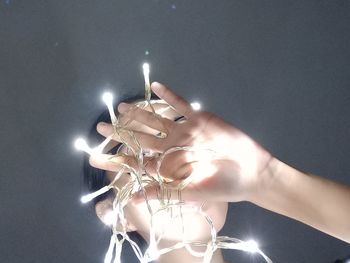 Midsection of person holding illuminated lighting equipment