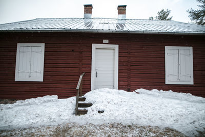 Snow on house roof against sky