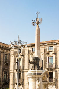 Low angle view of statue in city against clear sky