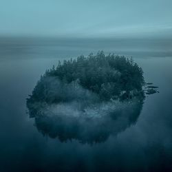 Scenic view of island at sea against sky