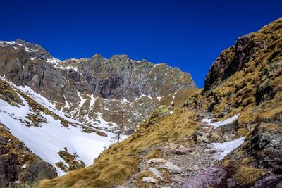 Scenic view of snowcapped mountains against clear blue sky