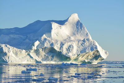 View of majestic iceberg in sea against sky