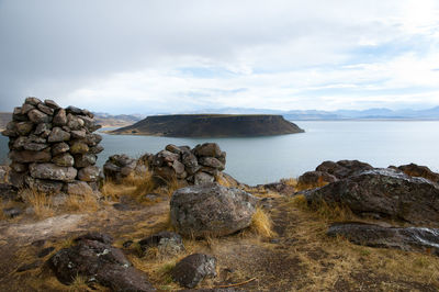 Scenic view of rocks on sea against sky