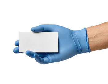 Close-up of hand holding eyeglasses against white background