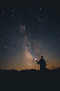 Silhouette man standing against star field at night