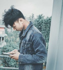 Side view of young man looking at camera