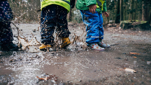 Lower section of children playing in puddle