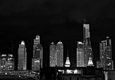 Illuminated buildings in city against sky at night