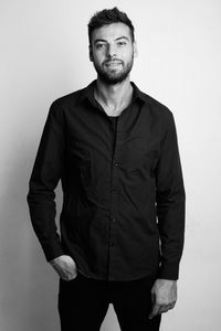 Portrait of man standing against white background