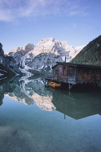 Scenic view of lake by snowcapped mountains against sky