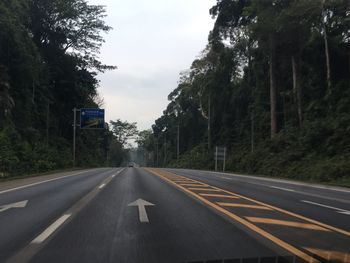 Road amidst trees against sky