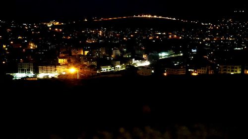 Illuminated cityscape against sky at night