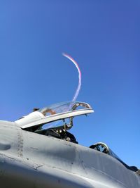 Low angle view of airplane flying against clear blue sky