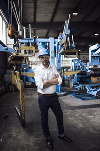 Full length portrait of man standing in factory