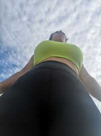 Low angle view of woman lying against sky