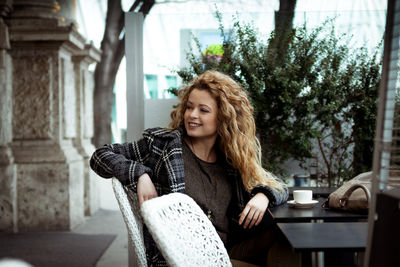 Portrait of young woman sitting at home