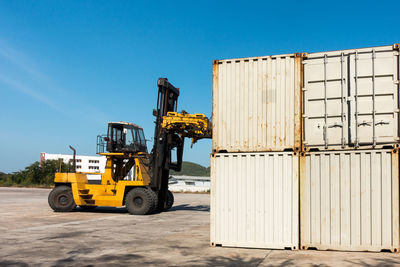 Cargo containers at dock against blue sky