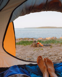 Low section of woman relaxing in tent