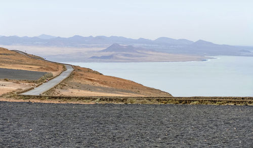 Scenic view of sea and mountains against sky