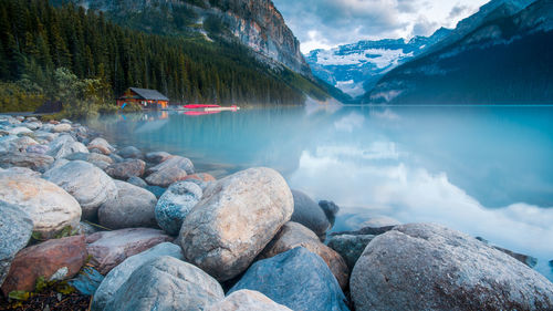 Scenic view of lake by rocks against sky