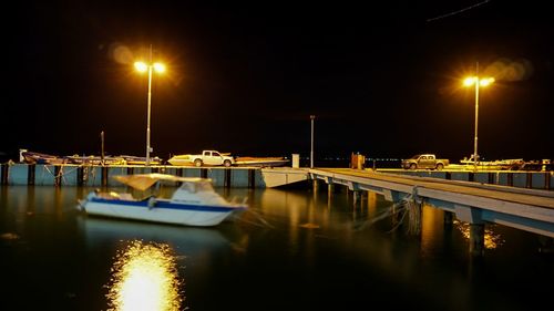 Illuminated boats in water at night