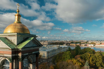 Buildings in city against cloudy sky