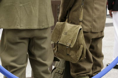 Rear view of people standing with bag