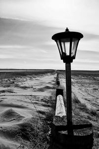 Lantern at beach against sky