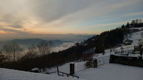 Scenic view of snowcapped mountains against sky during sunset