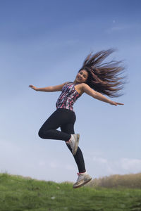 Full length of woman jumping against clear sky