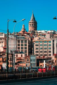 Buildings in city against clear blue sky