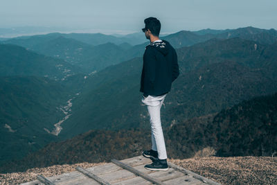 Rear view of man standing on mountain