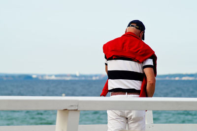 Rear view of a man overlooking calm lake