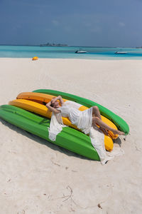 Rear view of woman with surfboard on beach