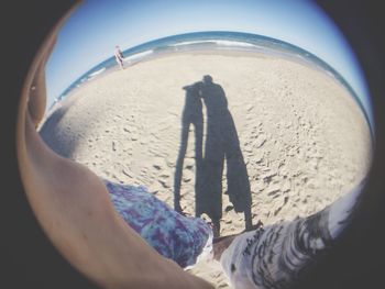 Close-up of people on beach against sky