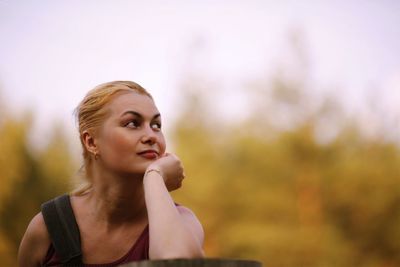 Thoughtful woman with hand on chin looking away