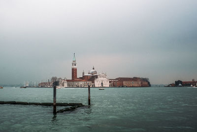 View of buildings by sea against sky